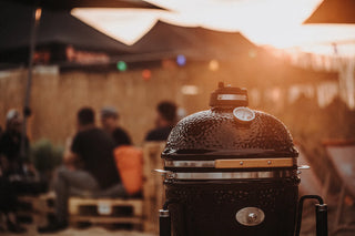 Black Monolith Kamado Grill with people in the background at an outdoor event