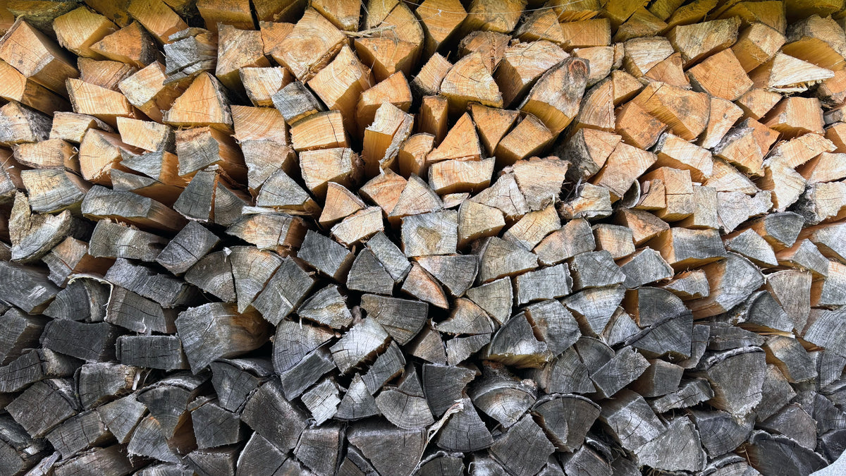 A neat stack of split firewood logs, cut ends facing out