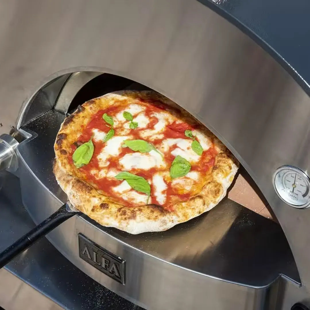 Pizza being taken out of Alfa Classico 2 Pizze Hybrid Gas pizza oven