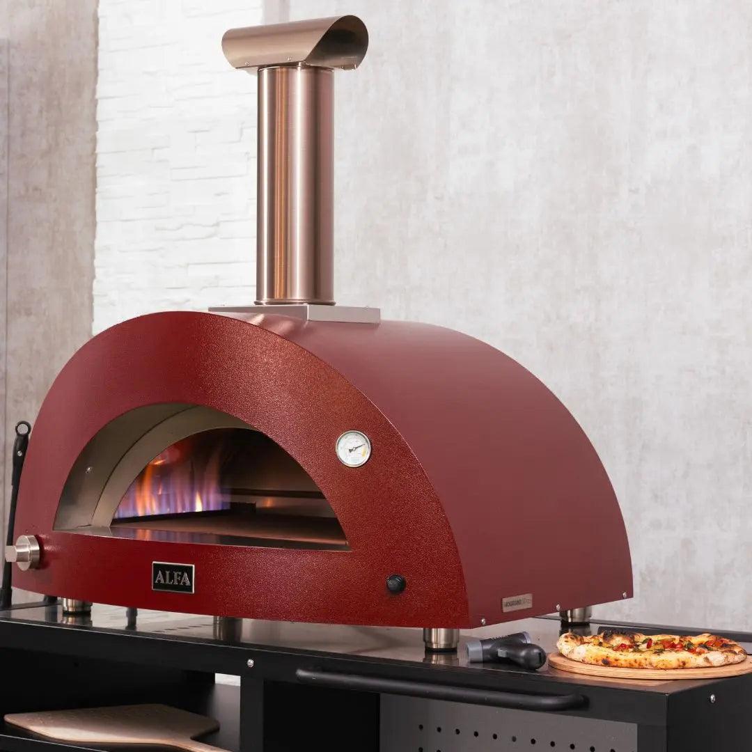 Alfa Moderno 2 Pizze Hybrid Pizza Oven in Antique Red outside with pizza being prepped