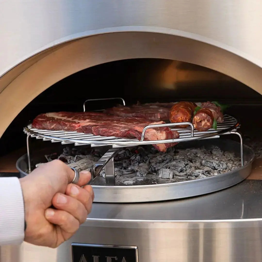 Person using tongs to handle meat on a grill inside a pizza oven.