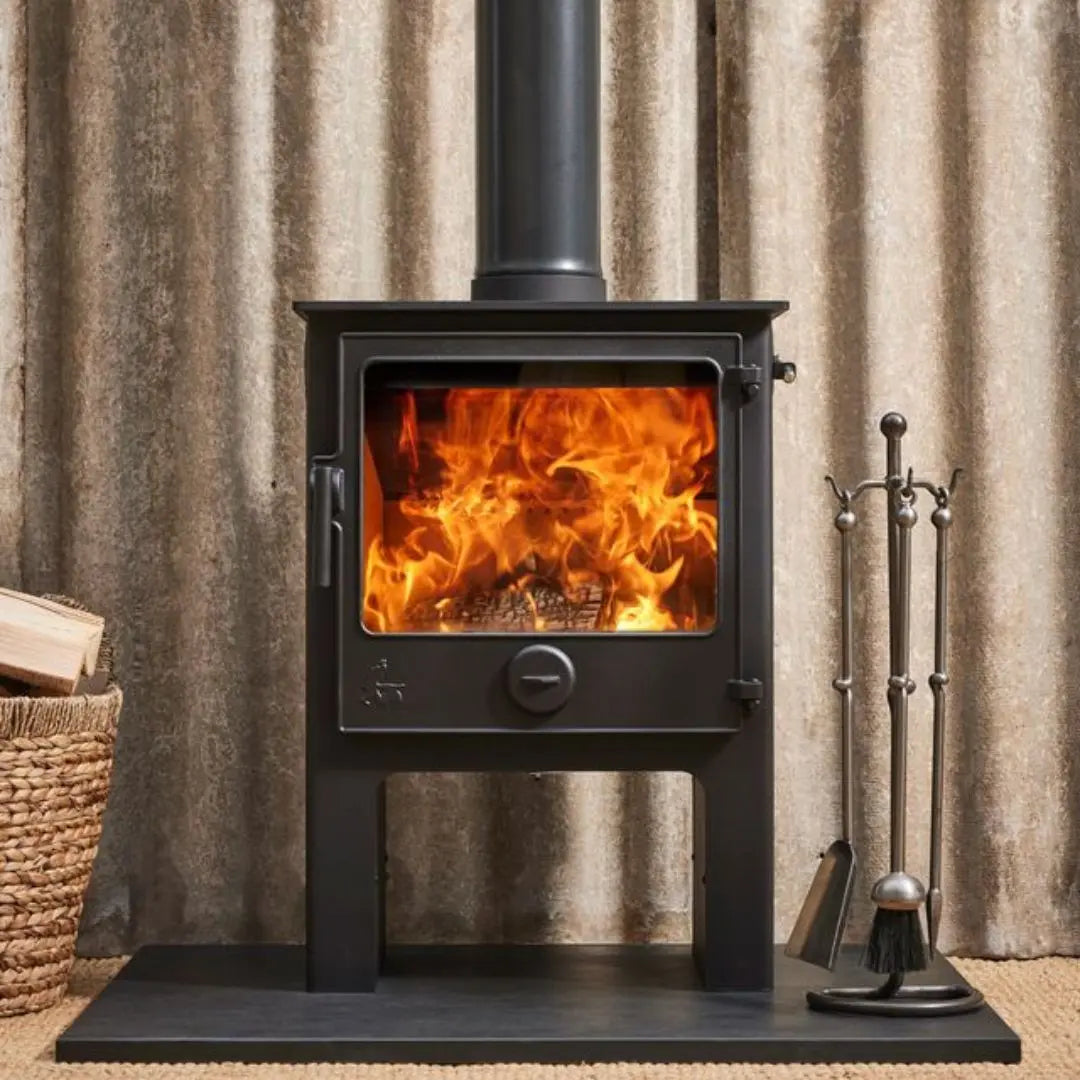 Dean Forge Dartmoor 8 Eco High Stove - 8kW on black hearth with companion set and log basket