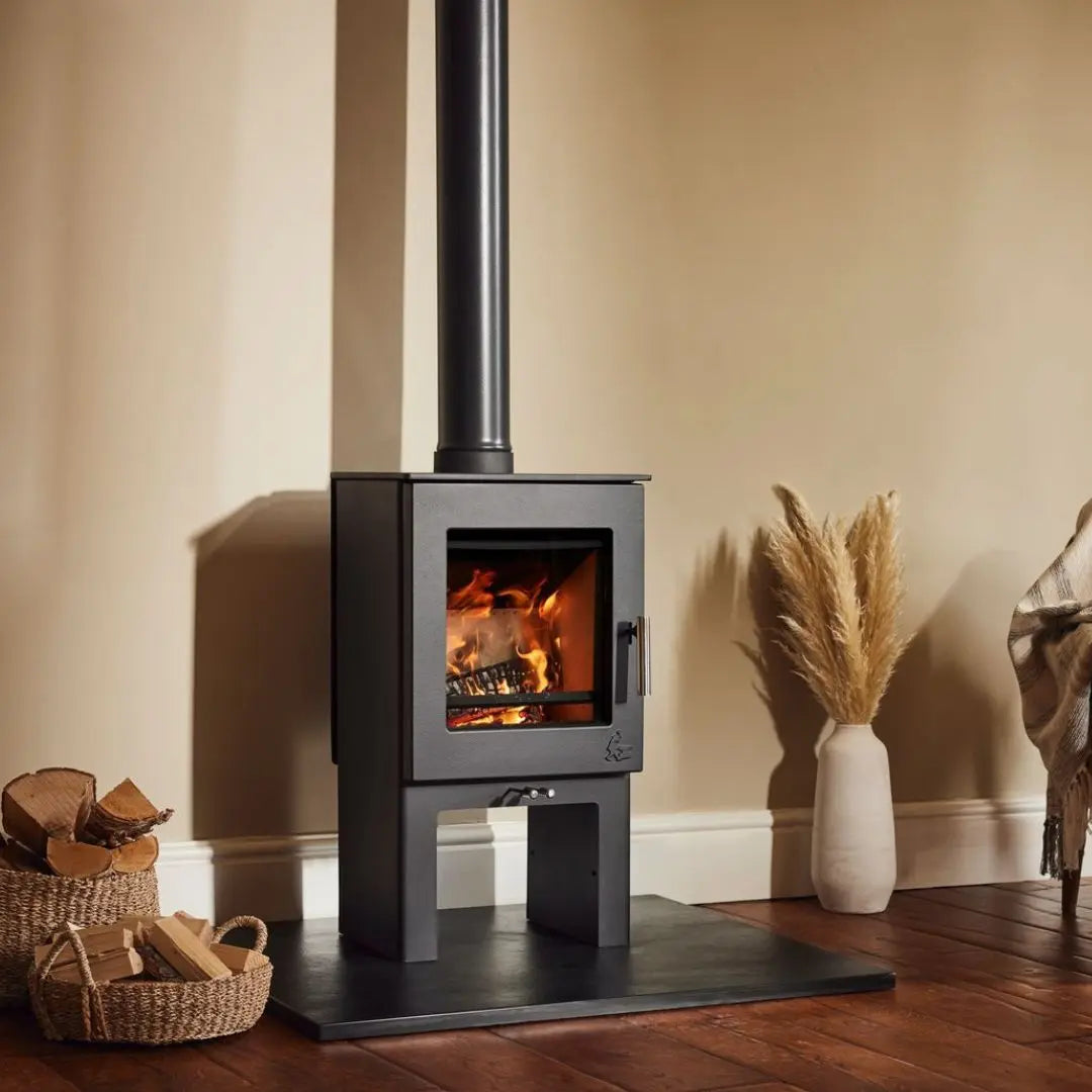 Dean Forge Sherford 5 High Eco Stove - 5kW on black hearth with flue and log baskets