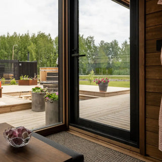 Modern patio with wooden deck, glass doors, and outdoor furniture.
