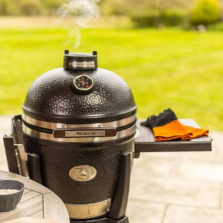 Black Monolith Avantgarde grill on a patio with a grassy area in the background