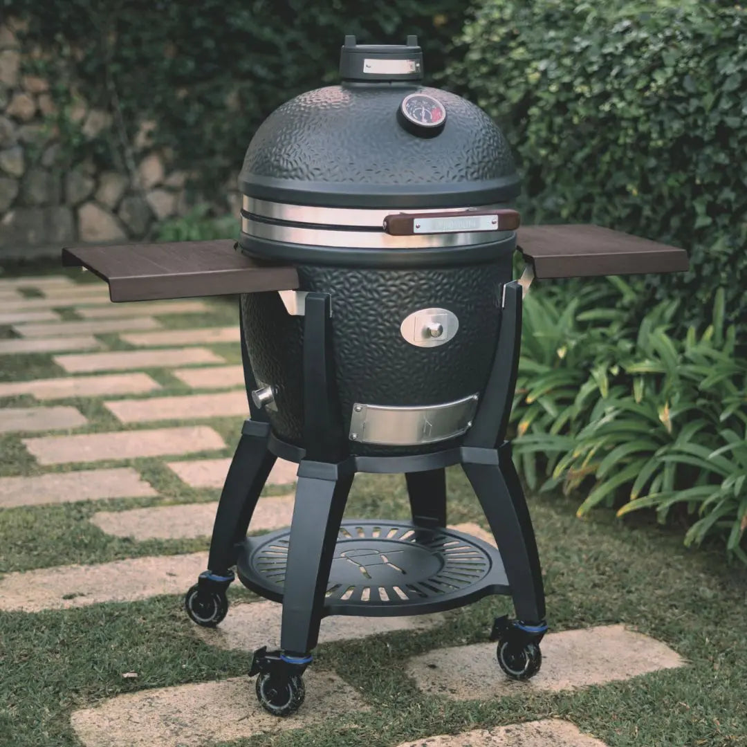 Monolith Avantgarde kamado outdoor grill bbq with cart and wooden side tables on a patio