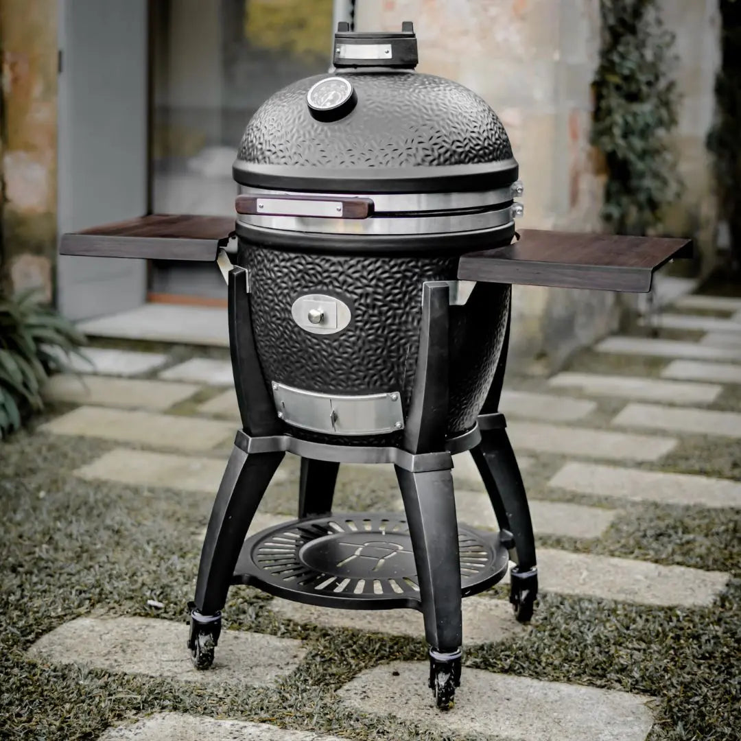 Monolith Avantgarde Black Kamado grill on a stone patio