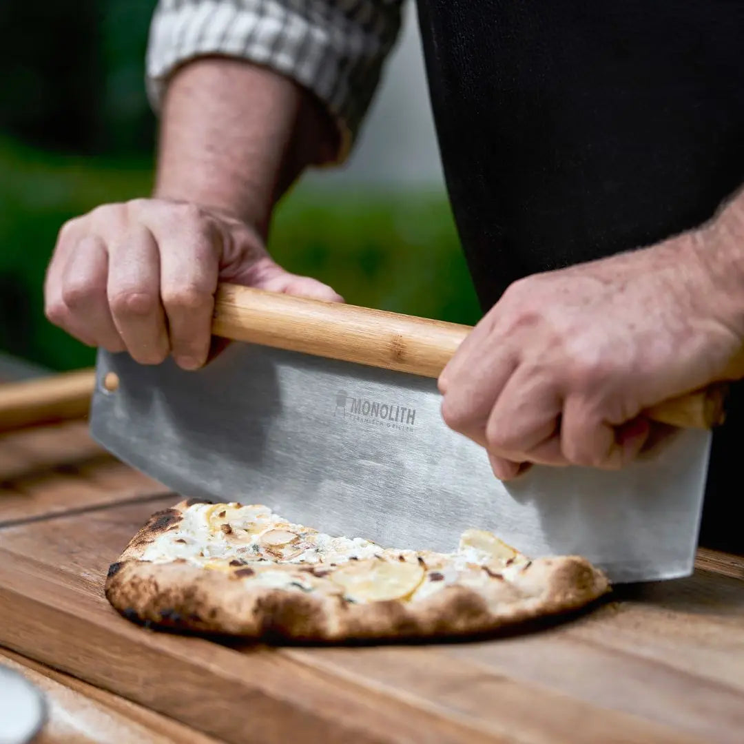 Monolith Kamado Grill Pizza Cutter cutting pizza