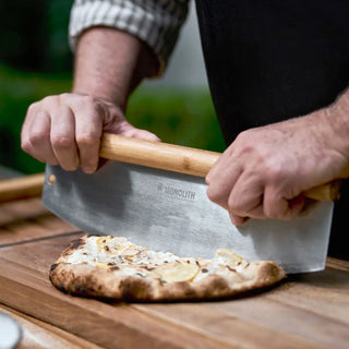 Monolith Kamado Grill Pizza Cutter cutting pizza