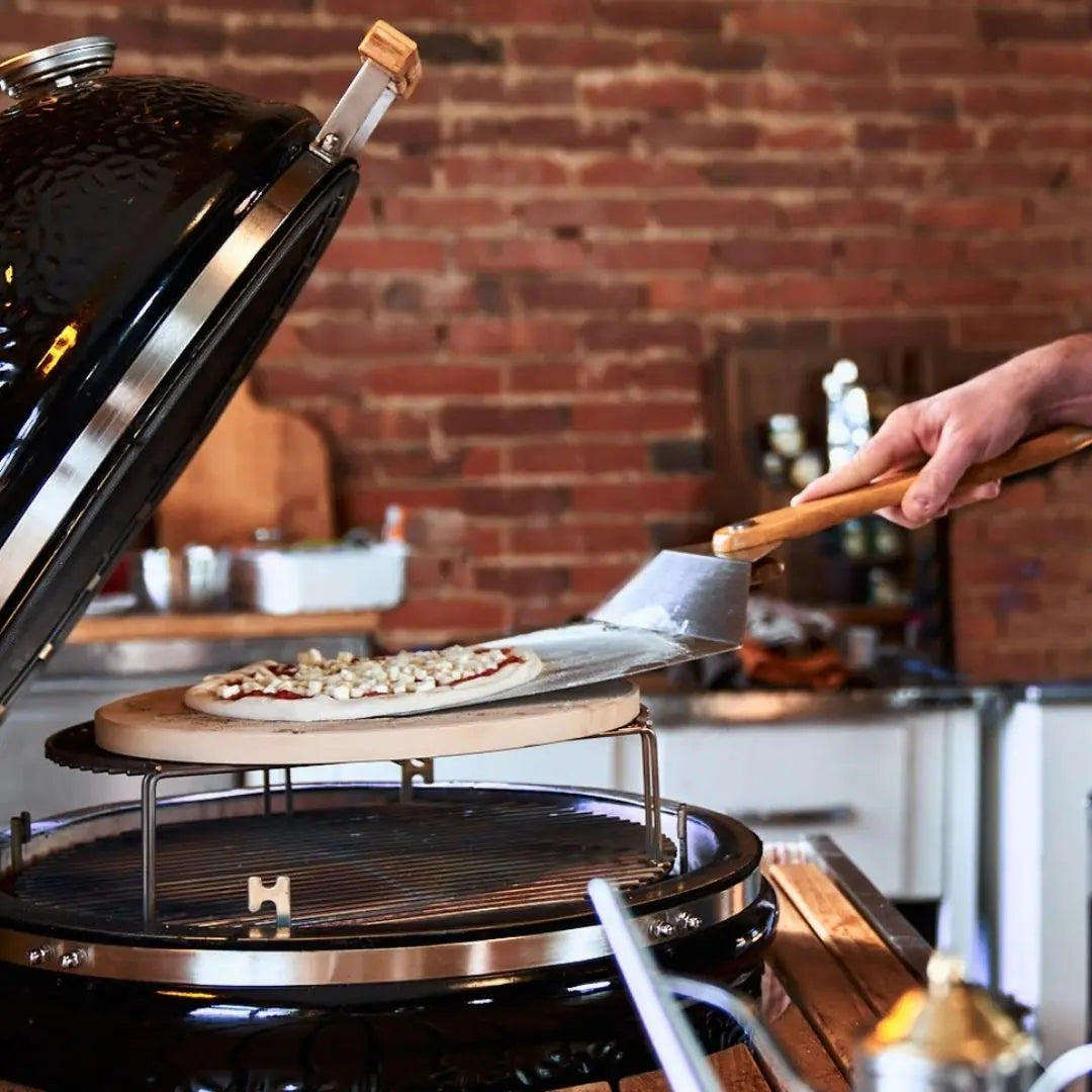 Monolith Kamado Grill Pizza Peel sliding pizza into grill