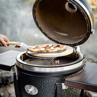 Monolith Kamado Grill Pizza Stone sliding pizza onto grill