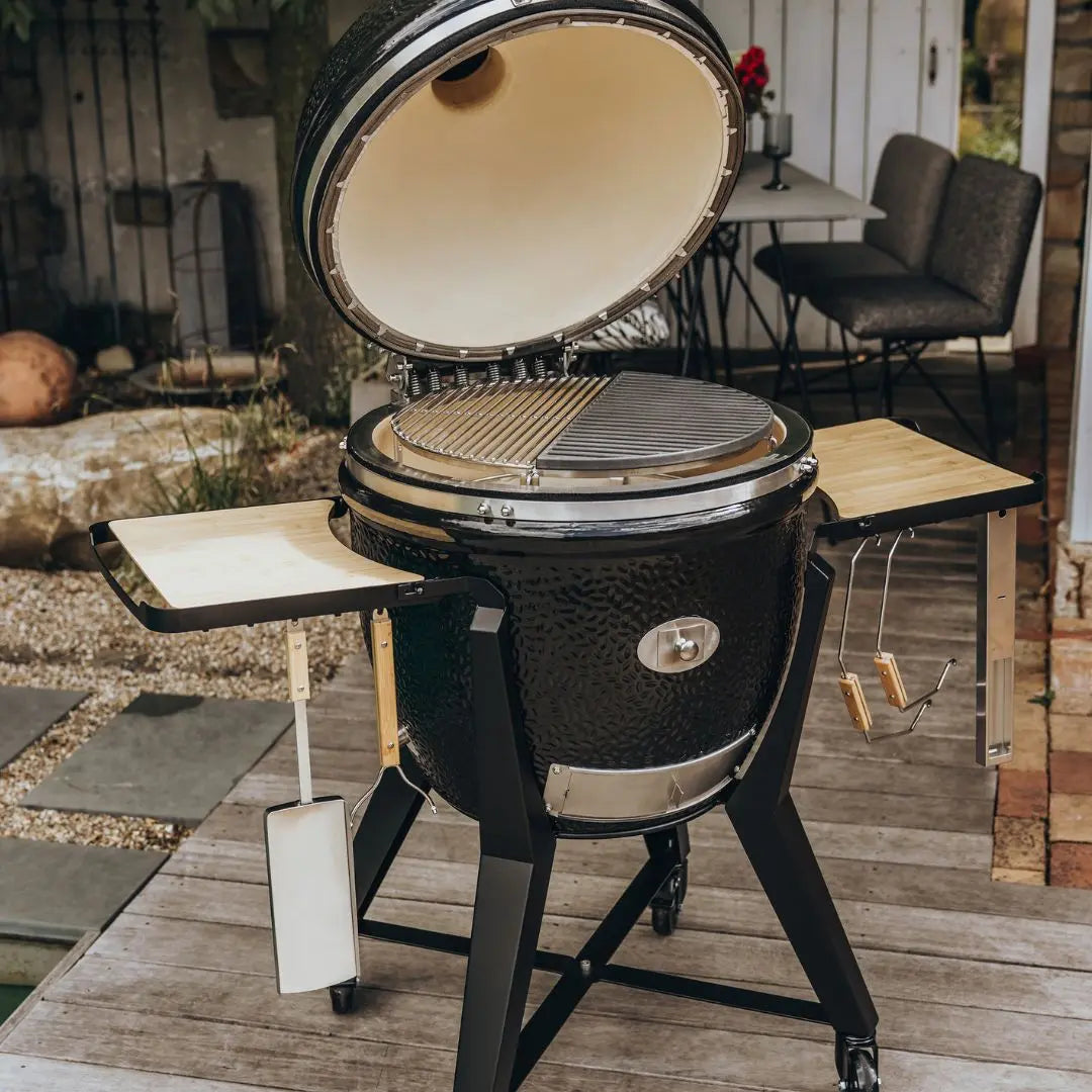 Monolith TWO 66cm Black kamado grill with cart and accessories on decking