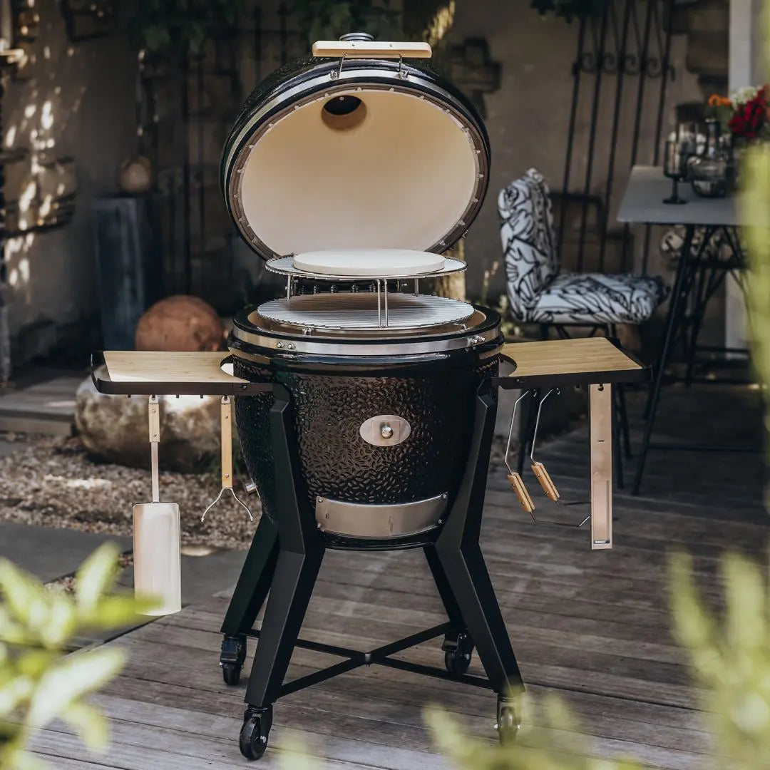 Monolith TWO 66cm Black kamado grill with cart, accessories and pizza stone on patio