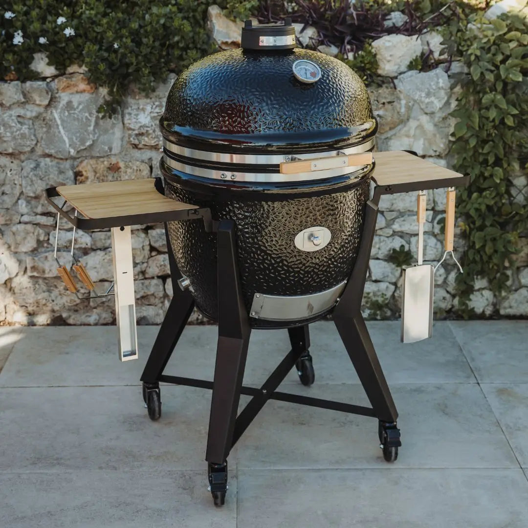 Monolith TWO 66cm Black kamado grill with cart and accessories on patio