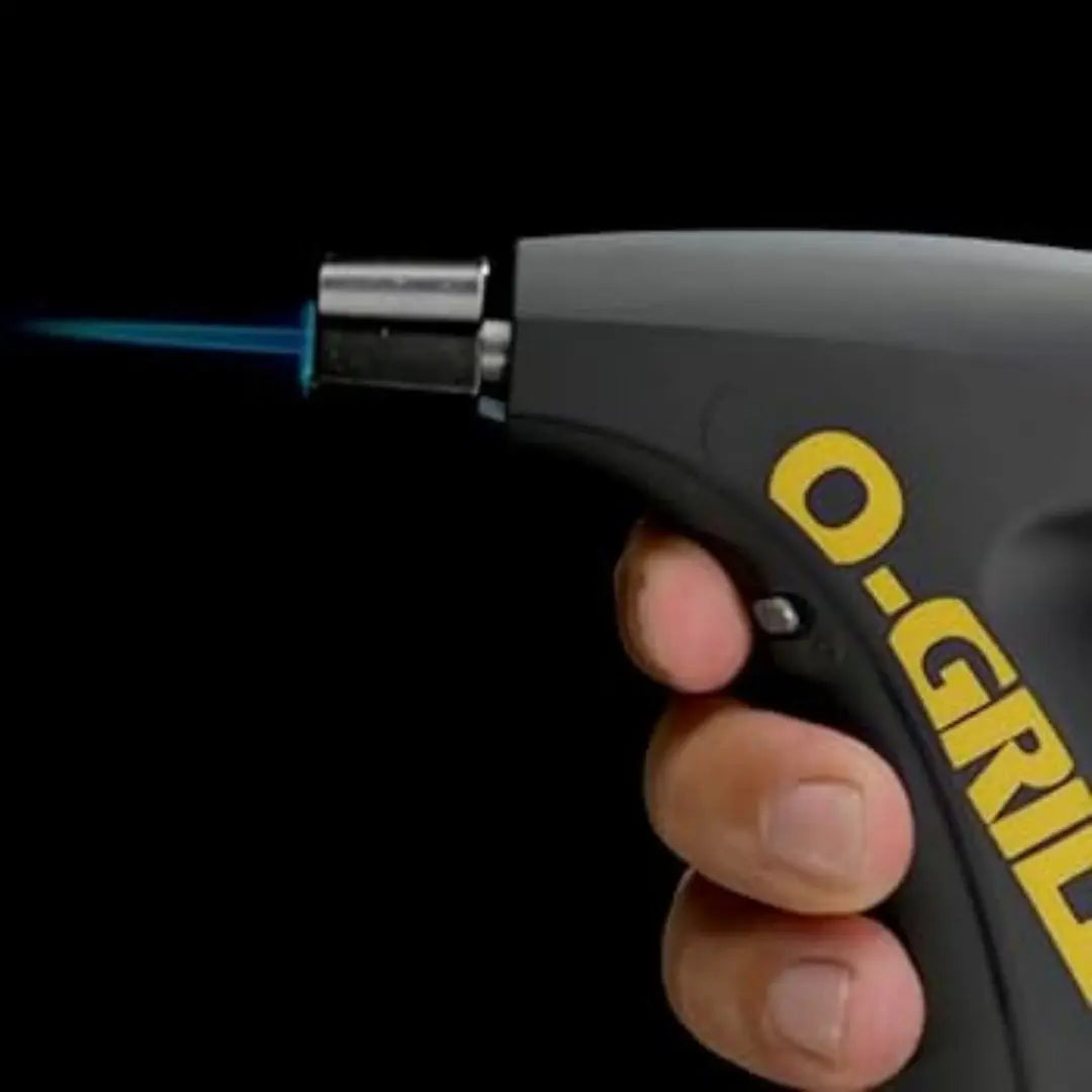 Hand holding a O-Grill torch lighter with a blue flame against a black background