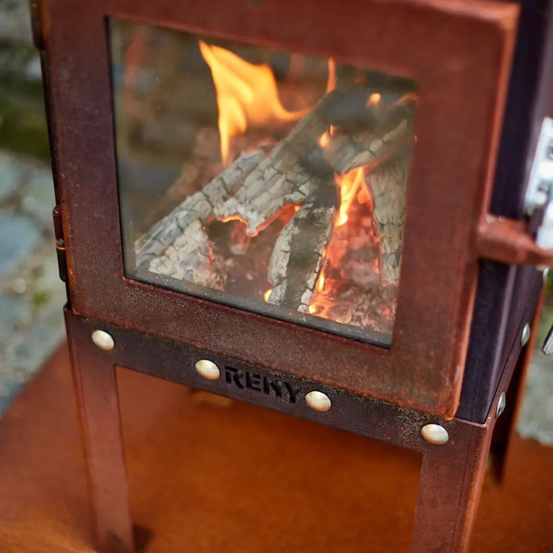 RB73 Piquia Outdoor Fireplace - Compact CorTen Steel Log Burner on outdoor patio setting