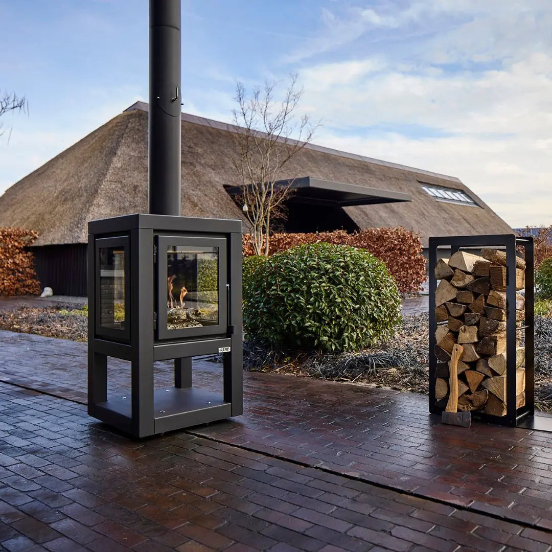 RB73 Quaruba XL Mobile outdoor fireplace in black on outdoor patio setting with logstore box