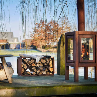 RB73 Quaruba XXL Outdoor Fireplace - CorTen Steel Wood Burner on decking setting with logstore box