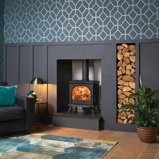 Living room with Stovax Huntingdon 30 wood burning stove with clear door, blue walls, and decorative rug.