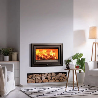 Stovax Vogue 700 Inset Wood Burning Stove - 7 kW on grey chimney wall with logs stacked